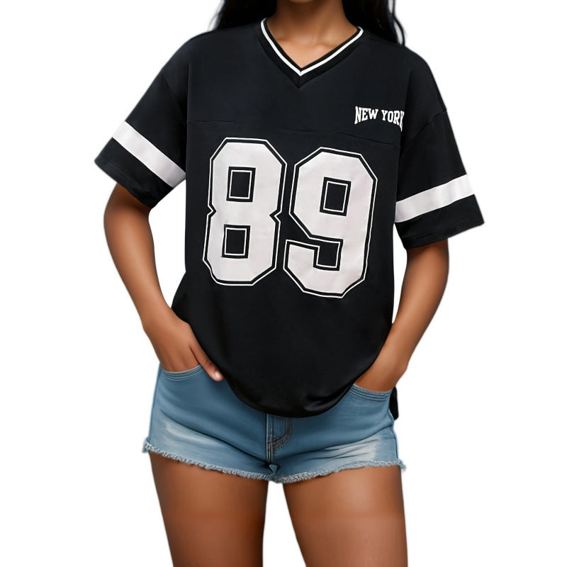 Femme portant un t-shirt noir avec numéro 89 et inscription "New York", associée à un short en jean. Mode décontractée, style urbain.