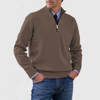 Homme portant un pull marron à col zippé, chemise bleue et jean. Mode masculine élégante, tenue décontractée chic, style automne-hiver.