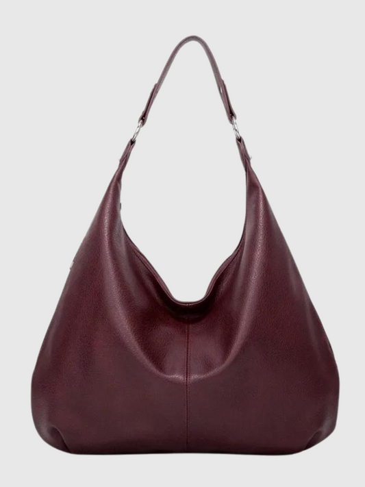 Bordeaux skuldertaske i læder med minimalistisk design, rummelig indvendig plads og justerbar rem. Perfekt til hverdagsbrug og stilfulde outfits.