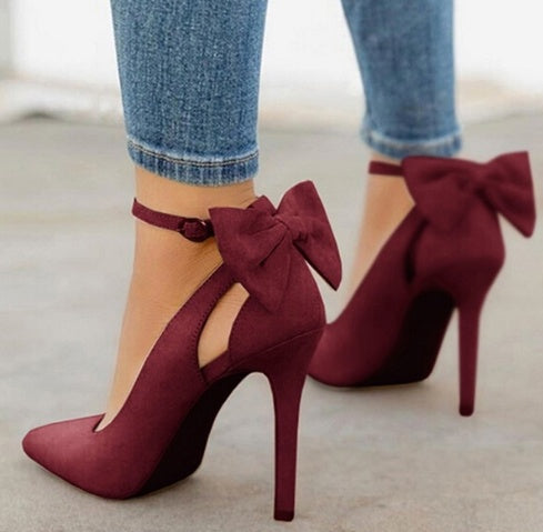 Escarpins bordeaux à talons hauts avec nœuds, portés avec un jean ajusté. Chaussures élégantes pour femmes, mode automne chic.