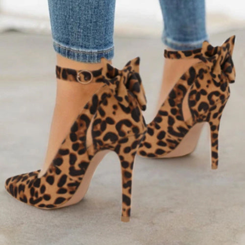 Chaussures à talons hauts léopard avec nœud, portées avec un jean. Mode féminine élégante, tendance imprimé animal, style chic et moderne.