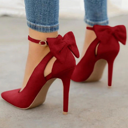 Escarpins rouges à talons hauts avec nœuds, portés avec un jean. Chaussures élégantes pour femmes, mode tendance, accessoires de soirée.