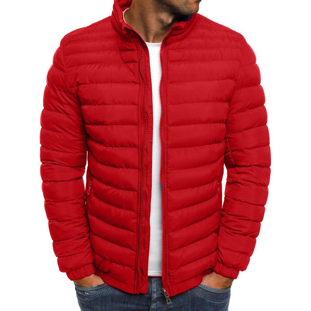 Homme portant une doudoune rouge matelassée, fermeture éclair, col montant, tenue décontractée, mode hiver, veste chaude pour homme.
