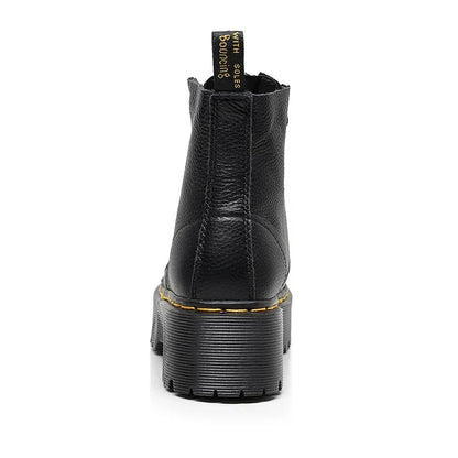 Botte noire en cuir avec semelle épaisse et surpiqûres jaunes, style Dr. Martens, vue arrière. Chaussure tendance, robuste et iconique.