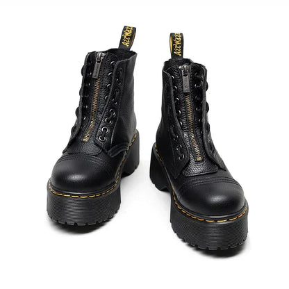 Bottes noires en cuir avec fermeture éclair, semelles épaisses et coutures jaunes. Chaussures tendance pour un look rock et moderne.