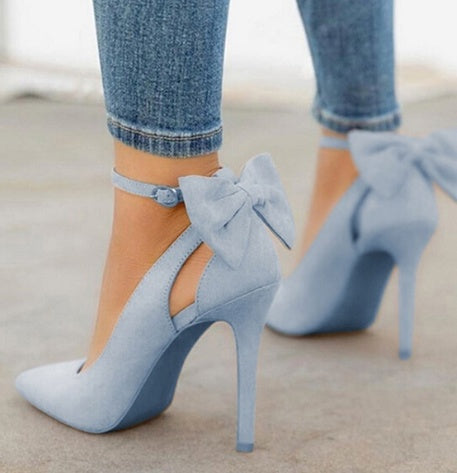 Escarpins bleu clair avec talons aiguilles et nœuds décoratifs, portés avec un jean ajusté. Chaussures élégantes pour mode féminine tendance.