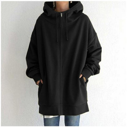 Veste à capuche noire unisexe, ample et zippée, avec poches avant, portée par une personne en jean. Mode décontractée, tendance automne-hiver.