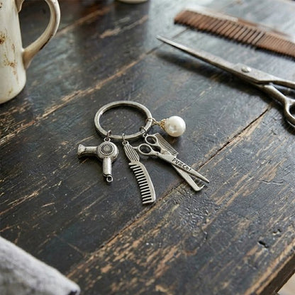 8721438355679 Zilverkleurige metaal sleutelhanger dames en heren met kappers charms – schaar, kam en föhn hanger met parel detail – stylist keychain voor kappers en hairstylists