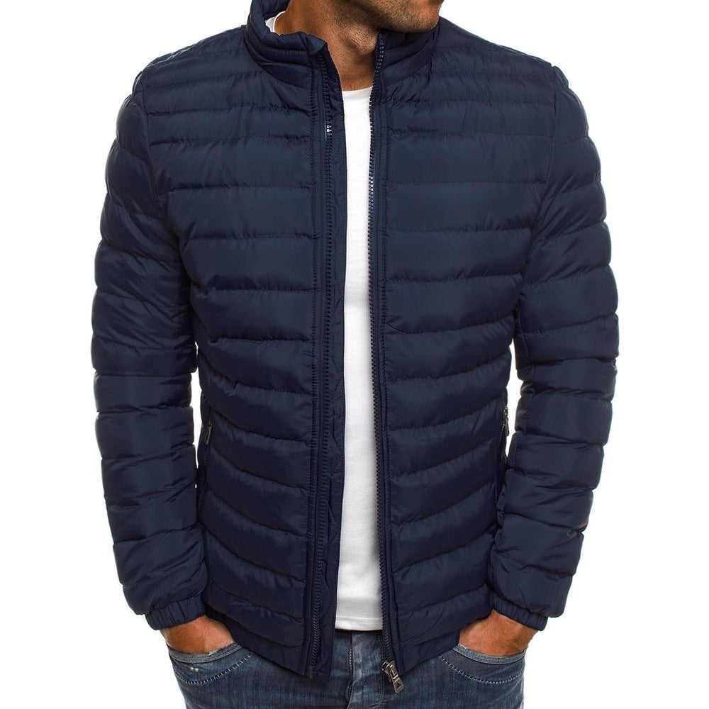 Homme portant une doudoune bleu marine, matelassée, avec fermeture éclair, sur un t-shirt blanc et un jean. Mode masculine, veste hiver tendance.