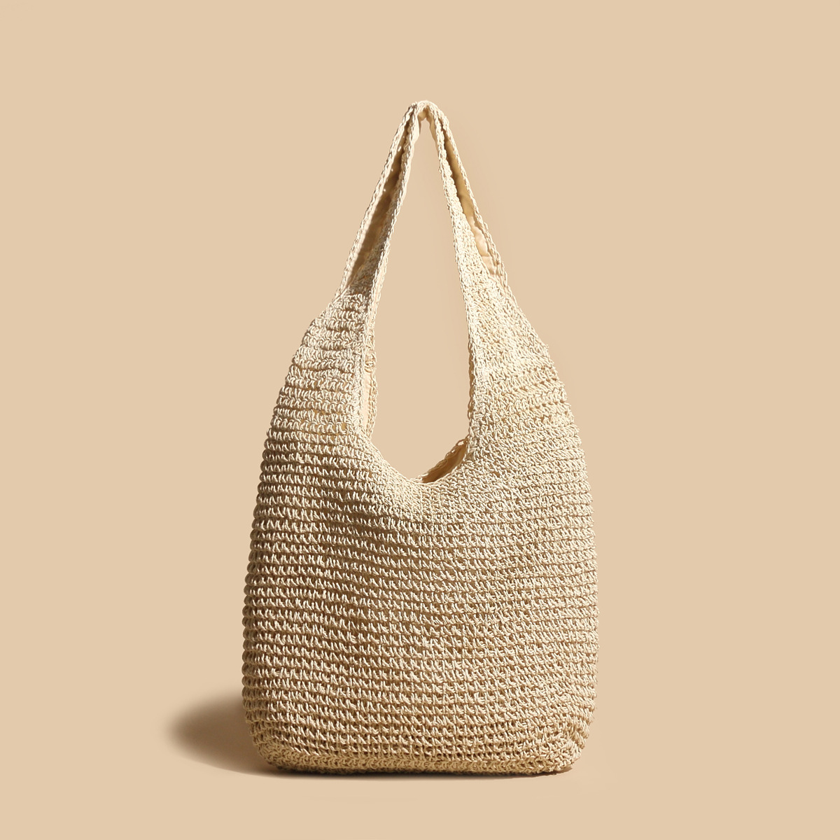 Sac en paille tressée beige sur fond uni, design minimaliste, mode éthique, accessoire d'été, tendance éco-responsable, style bohème chic.
