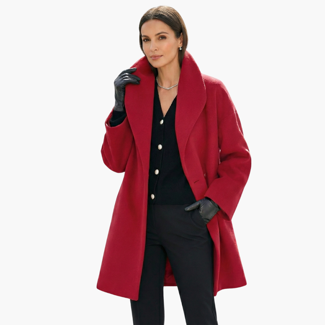 Femme élégante portant un manteau rouge, gants noirs et pull noir, posant avec assurance. Mode automne-hiver, style chic et sophistiqué.