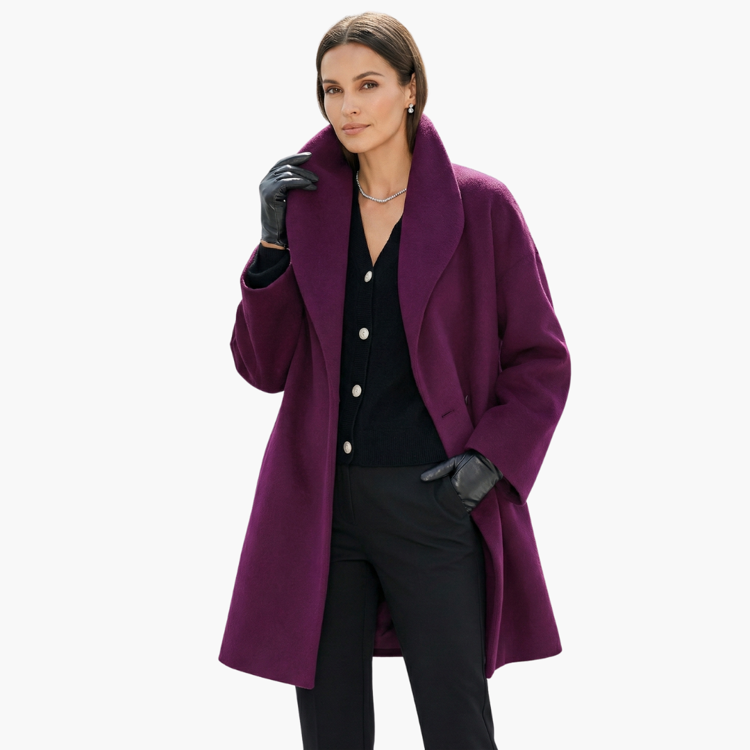 Femme portant un manteau violet élégant, gants noirs et collier argenté, posant avec assurance. Mode automne-hiver, style chic et moderne.