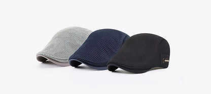Trois casquettes plates en maille respirante, couleurs gris, bleu et noir, sur fond blanc. Accessoires de mode élégants pour hommes.