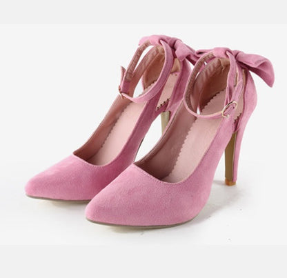 Escarpins roses en daim avec talons hauts et nœuds décoratifs, élégants et tendance, parfaits pour une tenue chic et féminine.