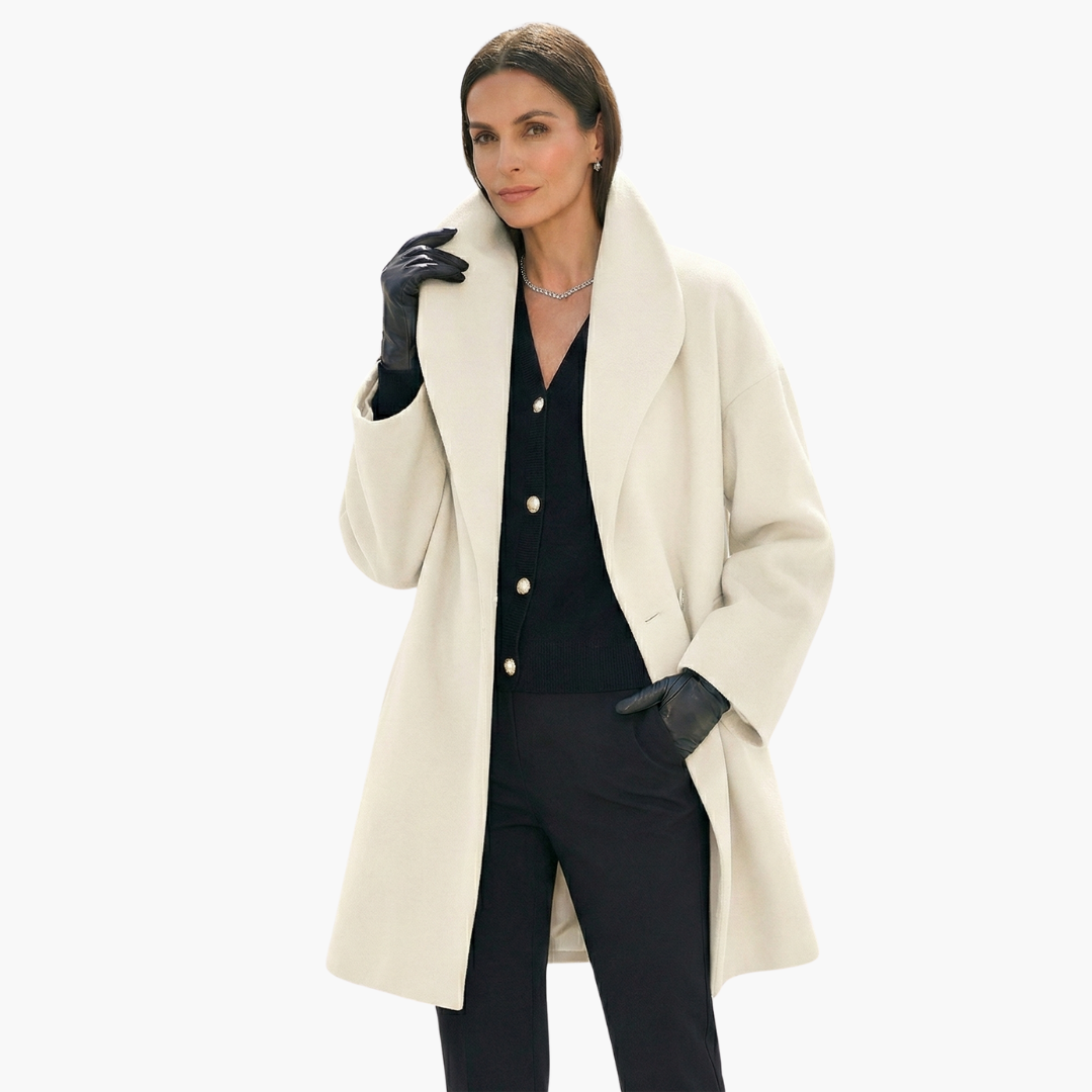 Femme élégante portant un manteau blanc chic, gants noirs et tenue noire, posant avec confiance. Mode automne-hiver, style sophistiqué et moderne.