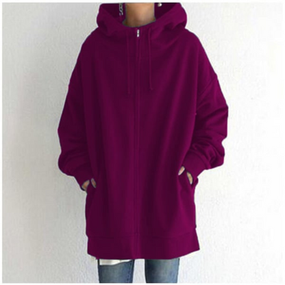 Hoodie bordeaux ample avec capuche, poches avant, porté par une personne debout. Mode décontractée, tendance automne-hiver, style urbain.