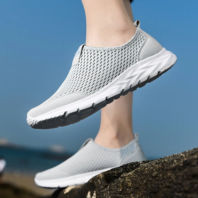 Chaussures de sport légères grises pour homme, semelle blanche antidérapante, design respirant, idéales pour la course et les activités extérieures.