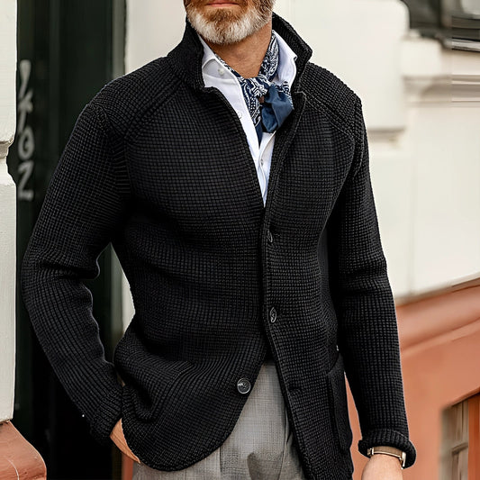 Men's black knit blazer styled as a designer formal cardigan, shown in Nero color and 3XL size. The blazer features a sleek design with a fashion-forward appeal, complemented by a white dress shirt underneath. The image highlights the texture of the knit fabric and the blazer's form-fitting silhouette, including the neckline, sleeves, and waist.