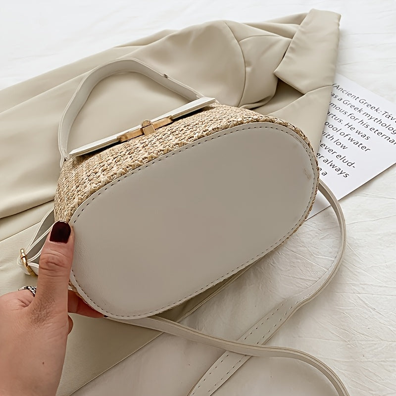 Sac à main en paille tressée avec base ovale blanche, posé sur un manteau beige. Élégant et tendance, idéal pour un look estival chic.