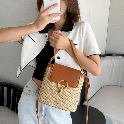 Femme tenant un sac à main en paille tressée avec rabat en cuir marron et boucle dorée, mode estivale élégante, tenue décontractée chic.