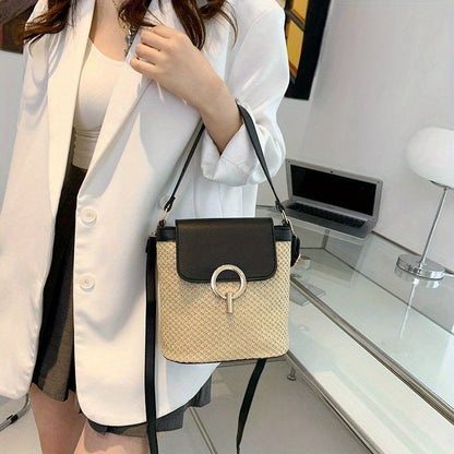 Sac à main en paille tressée avec rabat noir et boucle métallique, porté par une femme en blazer blanc. Accessoire mode élégant et tendance.