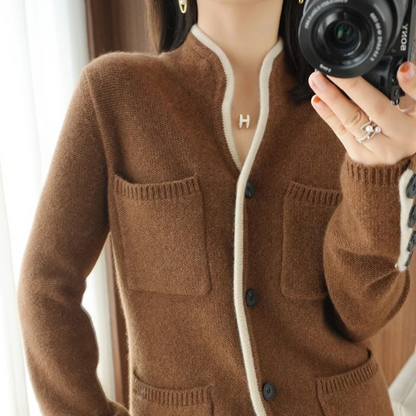 Brun cardigan med lommer og hvide kanter, bæres af kvinde med kamera. Striktrøje mode, efterårstøj, stilfuldt design, komfortabelt look.