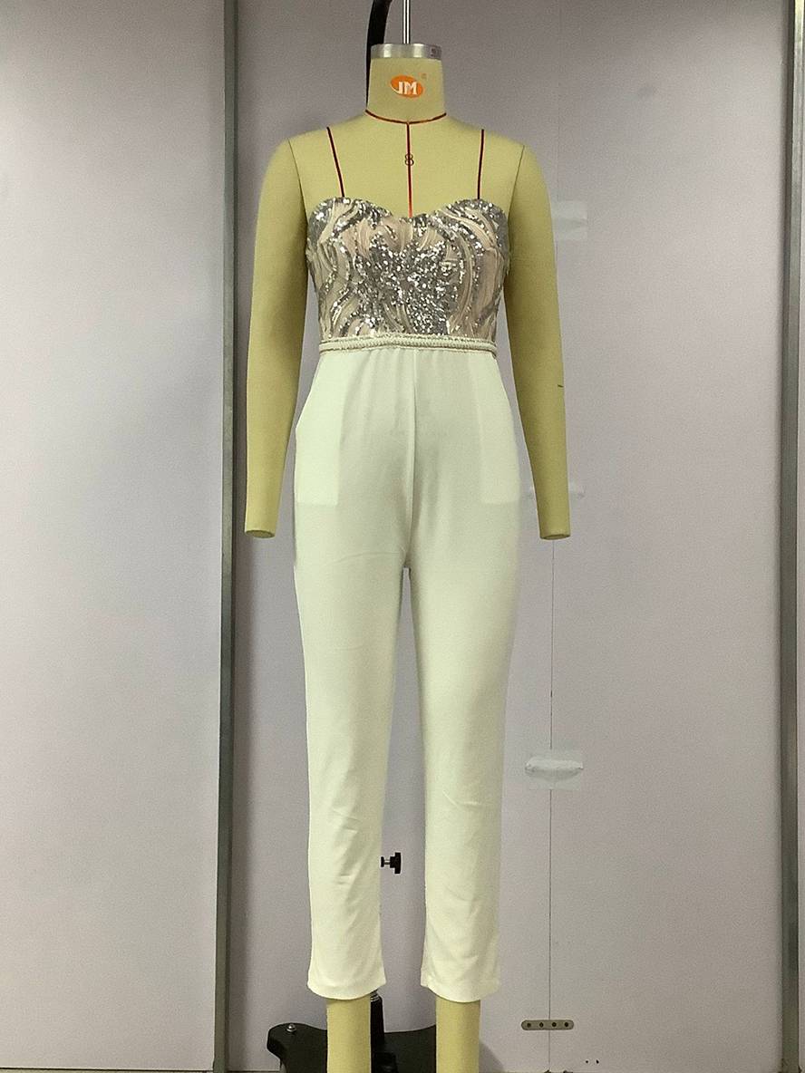 Combinaison élégante sur mannequin, haut brodé argenté et pantalon blanc, mode féminine chic, tenue soirée moderne, design raffiné.