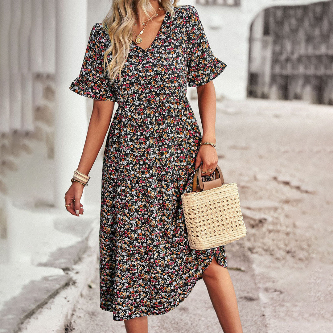 Robe fleurie femme, manches courtes, col en V, sac en osier, style bohème, rue pavée, mode été, tenue décontractée élégante.