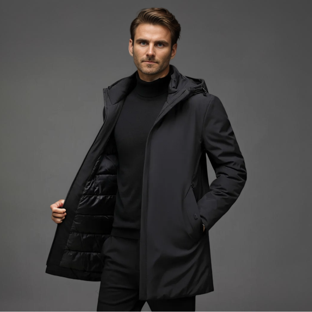 Homme portant un manteau noir élégant, intérieur matelassé, sur fond gris. Mode masculine, vêtement d'hiver, style moderne et chic.
