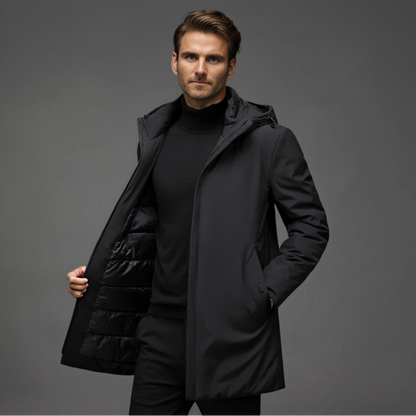 Homme portant un manteau noir élégant, intérieur matelassé, sur fond gris. Mode masculine, vêtement d'hiver, style moderne et chic.