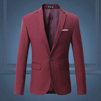Blazer homme bordeaux élégant, coupe ajustée, avec poche poitrine et deux poches à rabat, fond bleu. Veste formelle moderne pour occasions spéciales.