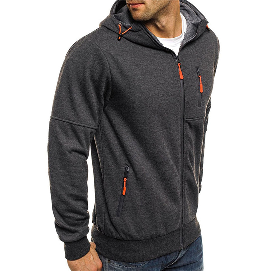 Homme portant un sweat à capuche gris foncé avec fermetures éclair orange, style décontracté, mode masculine, vêtement chaud, automne-hiver.