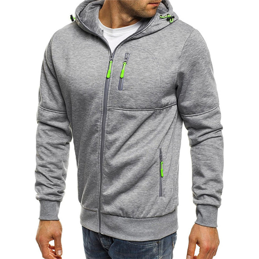 Homme portant un sweat à capuche gris avec fermetures éclair vertes, mode décontractée, vêtement tendance pour homme, style urbain moderne.