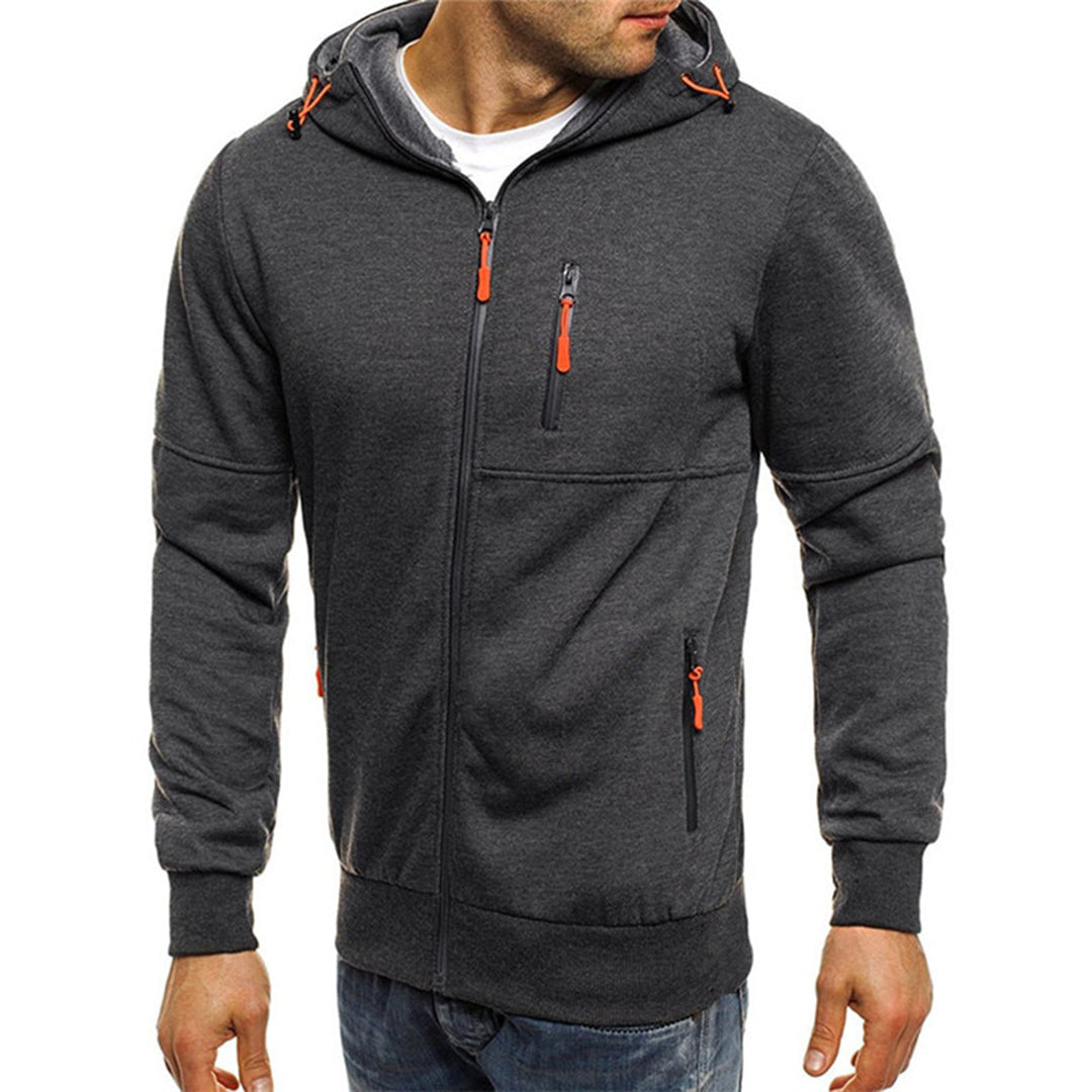 Homme portant un sweat à capuche gris foncé avec fermetures éclair orange, style décontracté, mode masculine, vêtement automne-hiver.