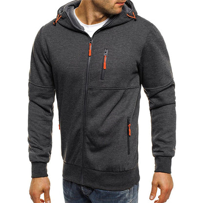 Homme portant un sweat à capuche gris foncé avec fermetures éclair orange, style décontracté, mode masculine, vêtement automne-hiver.