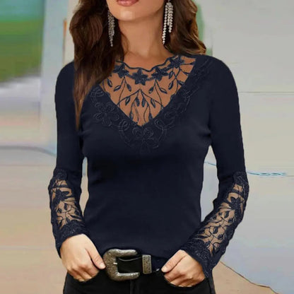Femme portant un pull noir élégant avec dentelle florale transparente sur le col et les manches, accessoirisé de boucles d'oreilles pendantes.