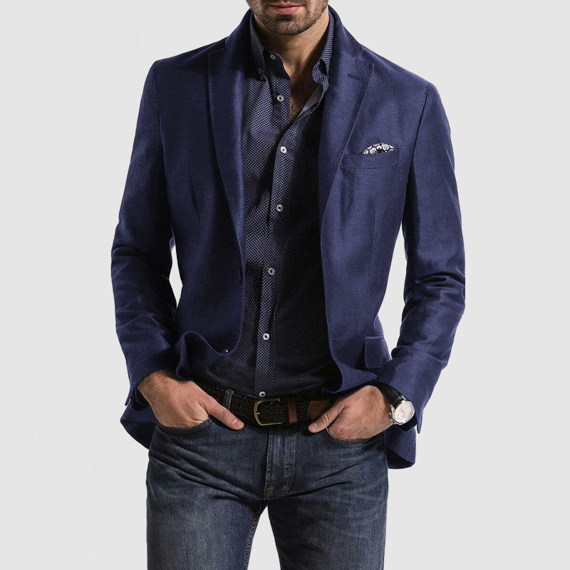 Homme portant une veste bleue élégante, chemise à motifs, jean décontracté et montre-bracelet. Mode masculine chic et moderne.