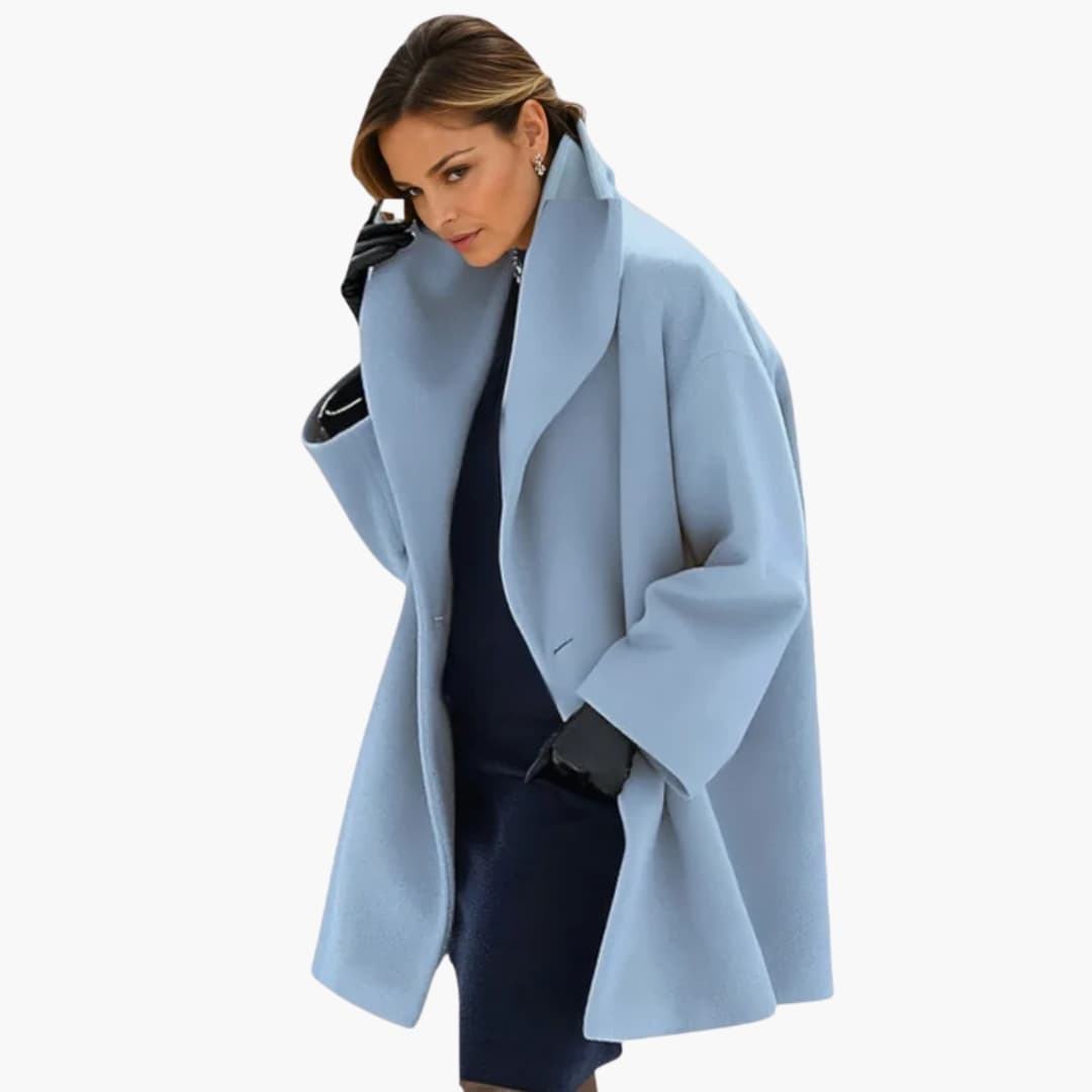 Femme portant un manteau bleu clair élégant, style oversize, avec des gants noirs, sur fond blanc. Mode hiver chic, tendance féminine.