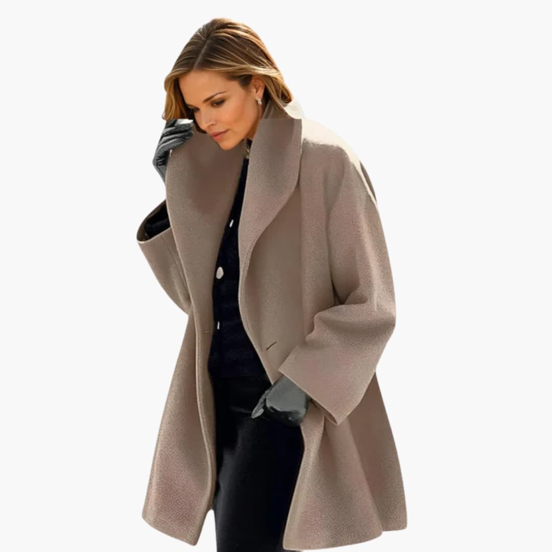 Femme portant un manteau beige élégant, gants noirs, sur fond blanc. Mode automne-hiver, style chic et moderne.