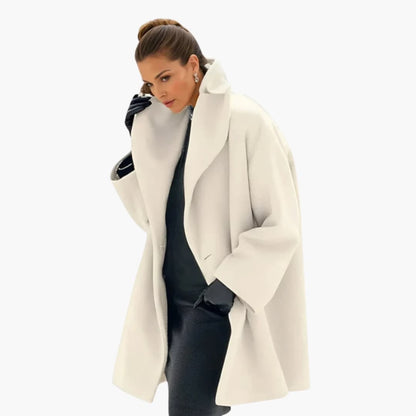 Femme élégante portant un manteau blanc oversize, gants noirs et coiffure soignée. Mode hiver chic, style sophistiqué, tendance vestimentaire.
