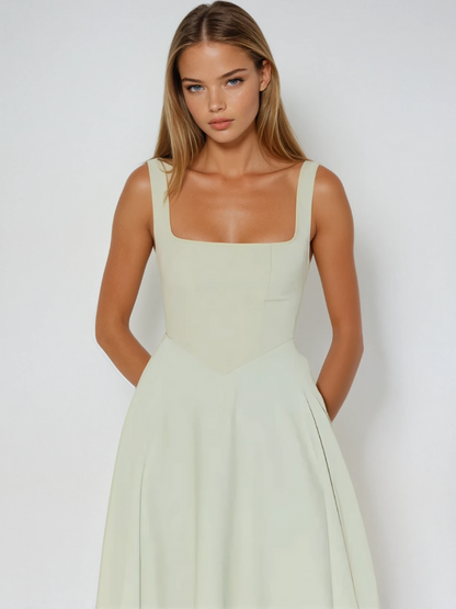 Midi dress featuring a square neckline and wide straps, designed for elegant occasions. The dress has a fitted bodice and a flowing skirt that falls to mid 1