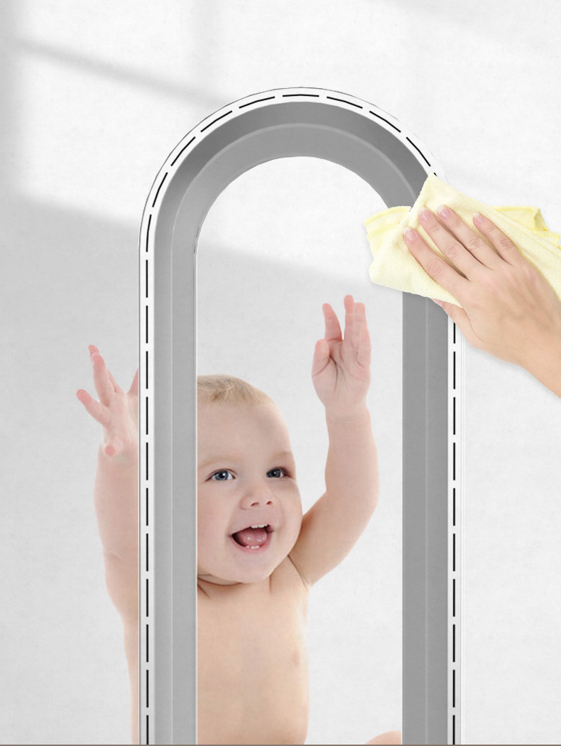 Bébé souriant jouant avec un ventilateur sans pales, main nettoyant l'appareil. Ventilateur Dyson, sécurité enfant, design moderne.