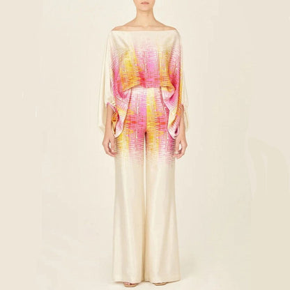 Robe longue élégante en soie beige avec motifs colorés rose et jaune, manches chauve-souris, style chic et moderne, mode féminine tendance.