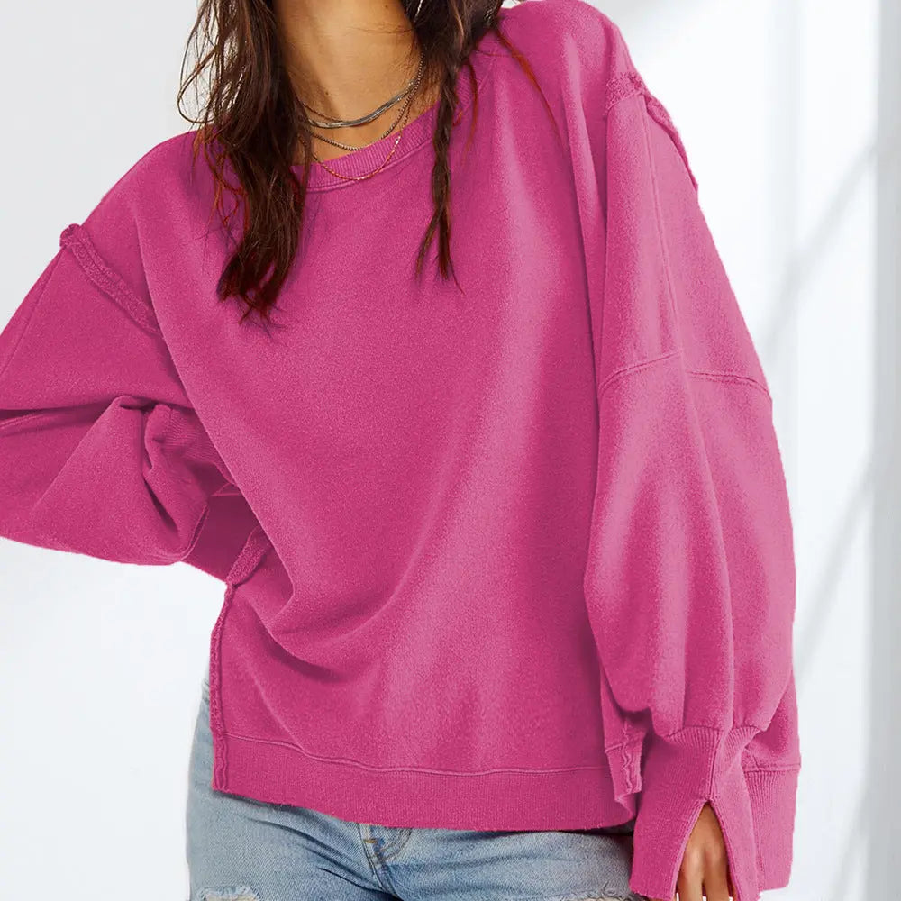 Femme portant un pull rose ample, manches longues, avec un jean décontracté. Mode féminine, style décontracté, tendance automne-hiver.