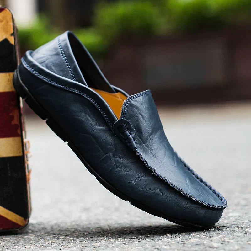 Mocassin en cuir bleu pour homme, élégant et confortable, posé sur une surface extérieure. Chaussure mode masculine, style décontracté.