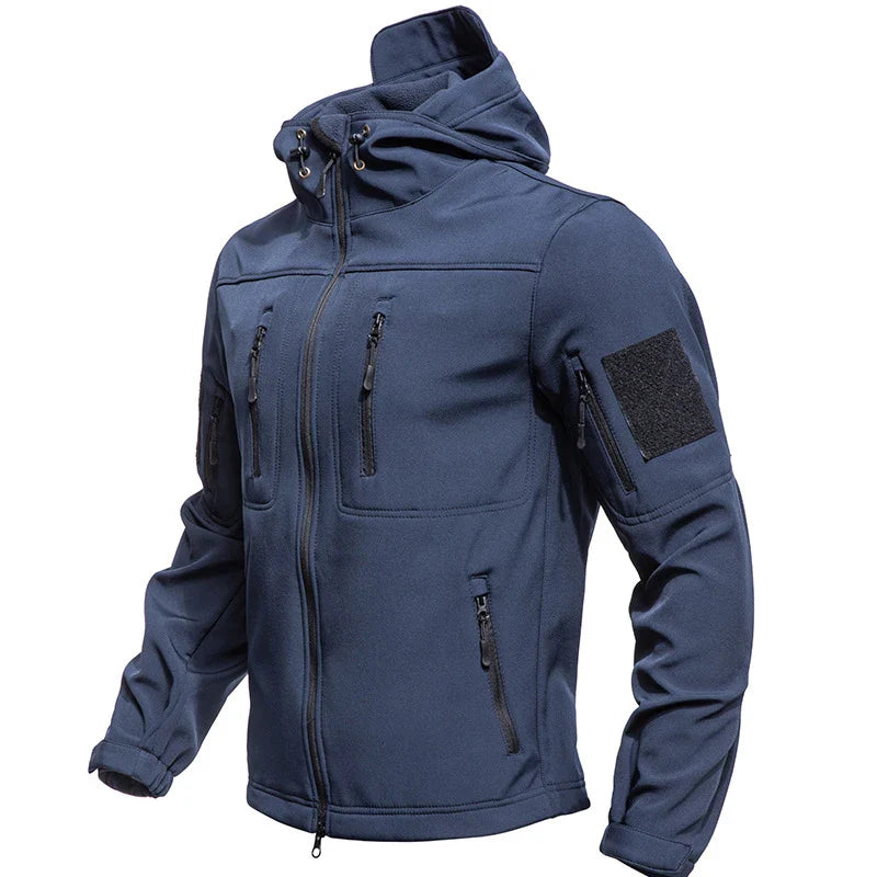 Blå softshell jakke med hætte, lynlåslommer og velcro på ærmet. Ideel til udendørs aktiviteter. Vandafvisende og vindtæt design.