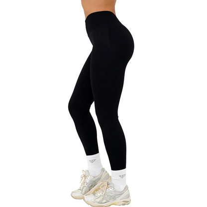 Sorte leggings til kvinder, høj talje, bæredygtigt materiale, komfortabel pasform, kombineret med hvide sneakers og sokker. Perfekt til træning.