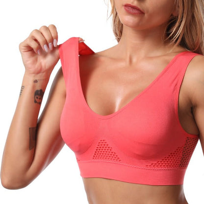 Femme portant un soutien-gorge de sport rose sans coutures, design respirant, confort optimal pour fitness et yoga. Mode active féminine.