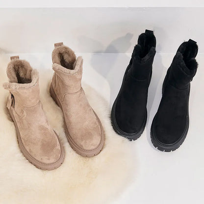 Deux paires de bottes d'hiver en daim, une beige et une noire, avec doublure en fourrure, posées sur un tapis blanc. Chaussures chaudes et élégantes.