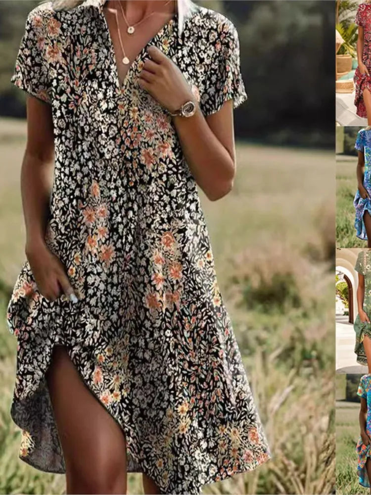 Robe d'été fleurie noire et blanche avec motifs floraux colorés, manches courtes, col en V, portée par une femme dans un champ. Mode féminine élégante.